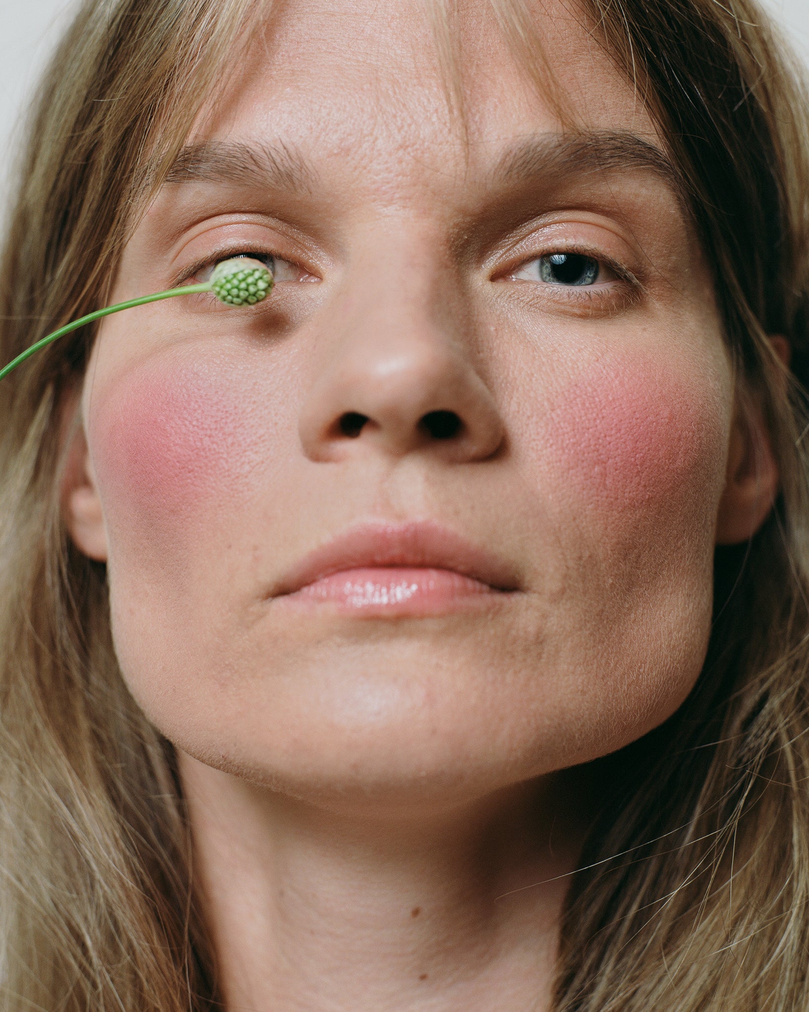 Model wearing MÁDARA Organic Skincare mineral cheek blush cold cheeks on A6823 on skin; close-up portrait shows natural application results.