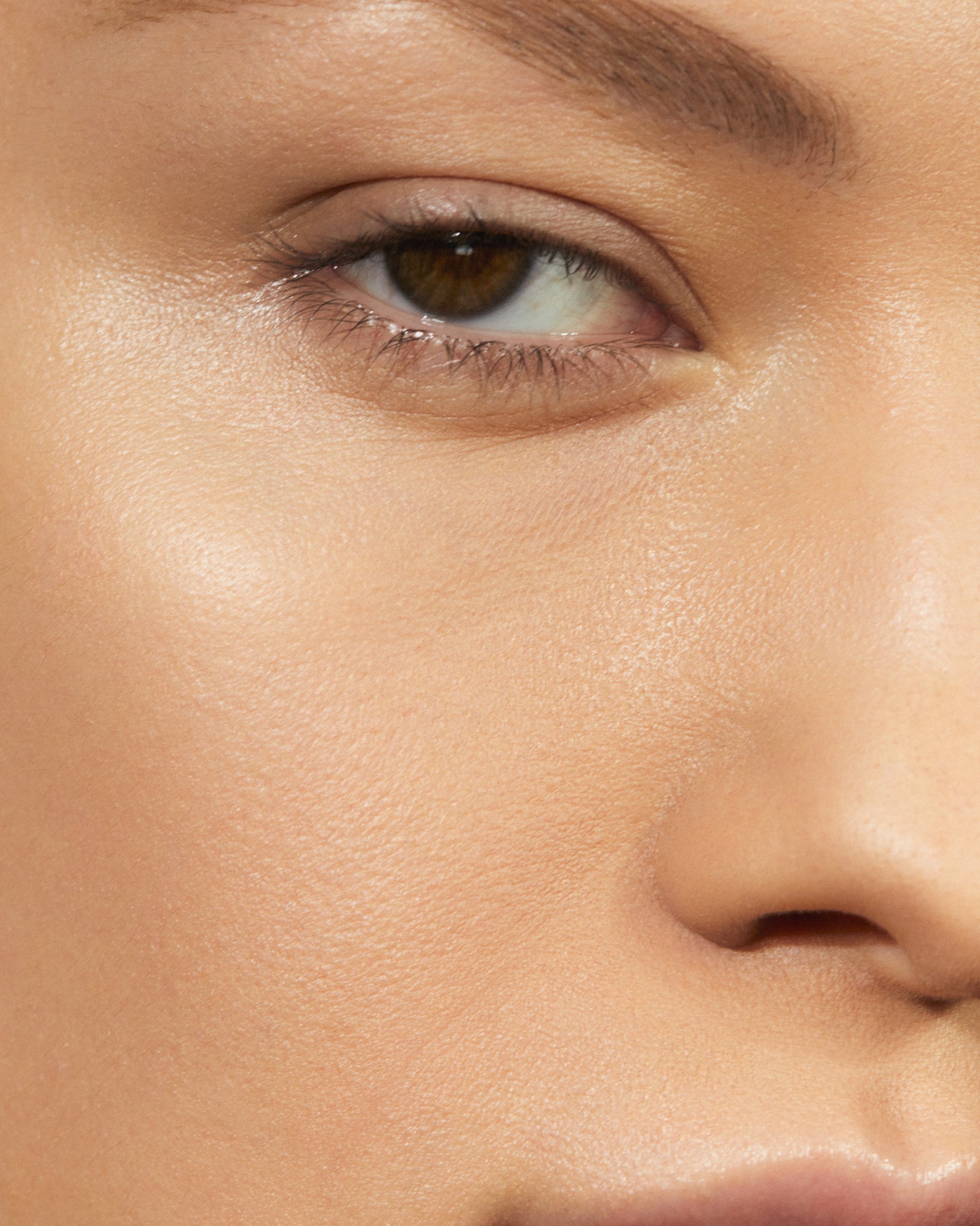 Model wearing MÁDARA Organic Skincare soft silk powder beige on A6802 on skin; close-up portrait shows natural application results.