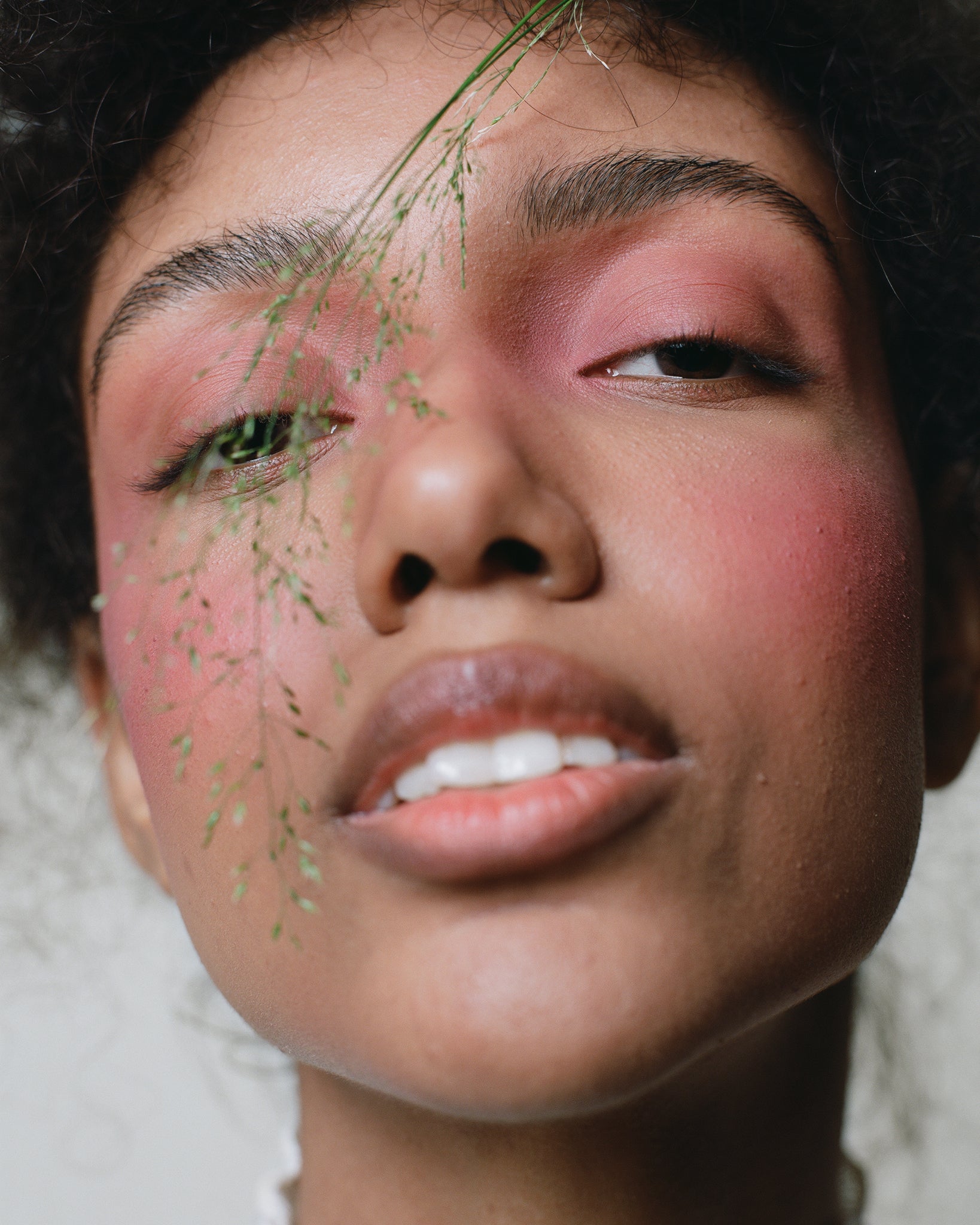 Model wearing MÁDARA Organic Skincare magnetic blush cold cheeks on A6823 on skin; close-up portrait shows natural application results.