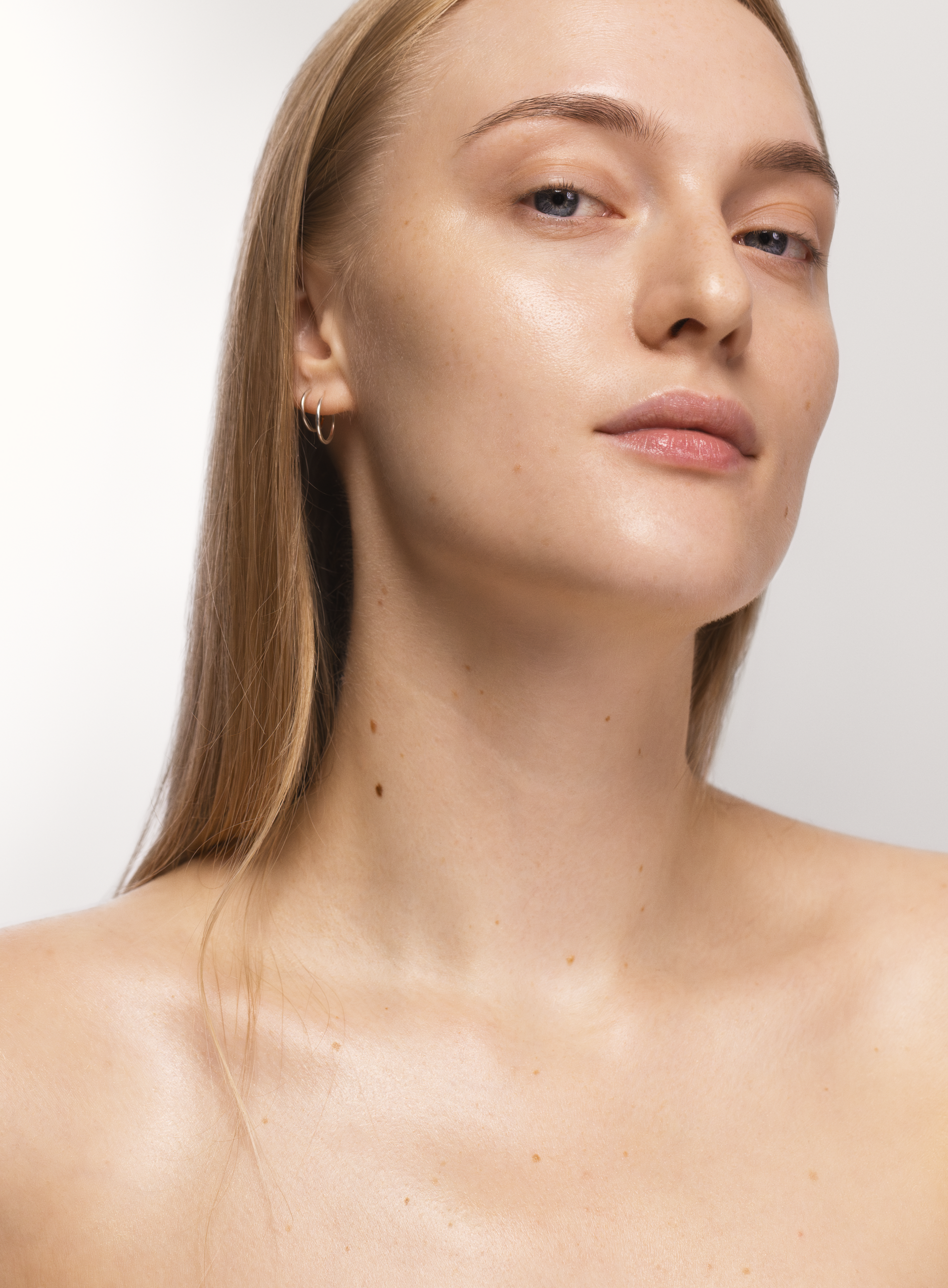 Portrait of a woman with luminous, hydrated, and glowing skin, showcasing the radiance achieved with MÁDARA Hydra Glow Hyaluron Peptide Serum